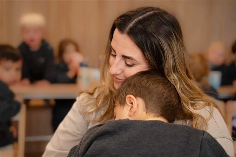 Educadora acompañando a un bebé en la bienvenida